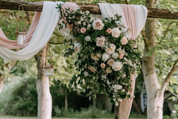 Arch for a wedding reception decorated with pastel roses and green leaves